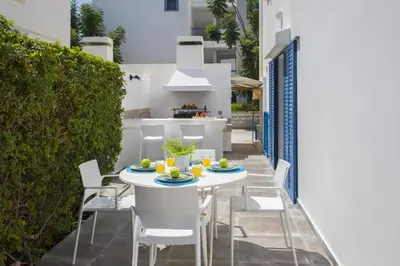 a patio with a white table and chairs at Protaras Villa Loulla in Protaras