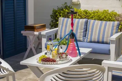 a table with a plate of fruit and a bottle on a patio at Protaras Villa Loulla in Protaras