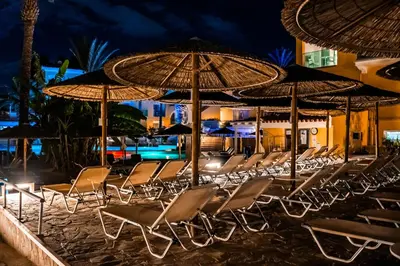 a group of chairs and umbrellas on a beach at Malama Beach Holiday Village in Protaras