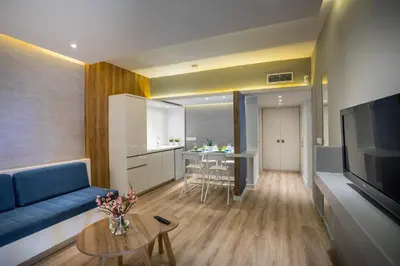 a living room with a blue couch and a table at Malama Beach Holiday Village in Protaras
