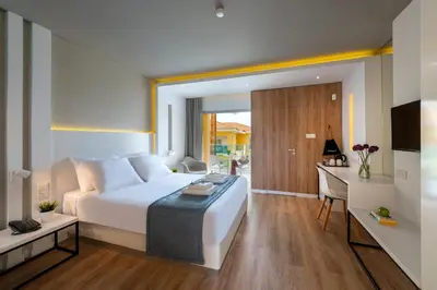 a hotel room with a bed and a desk and a room at Malama Beach Holiday Village in Protaras