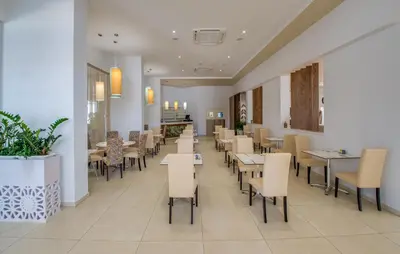 a dining room with tables and chairs in a restaurant at Stamatia Hotel in Ayia Napa
