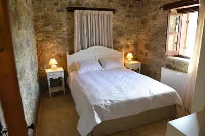 a bedroom with a white bed and two tables with lamps at Spiti tis Irinis in Pedoulas