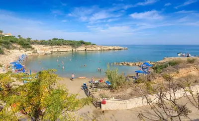 a beach with a bunch of people in the water at Villa Irina in Paralimni