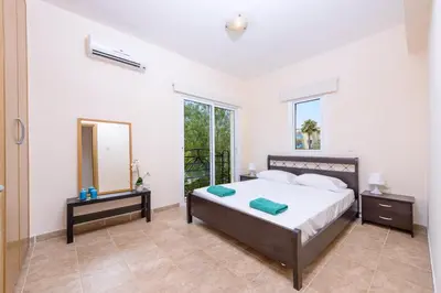 a bedroom with a large bed and a mirror at Villa Irina in Paralimni