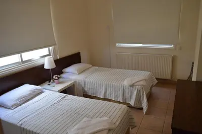 a hotel room with two beds and a window at Lordos Hotel Apts Limassol in Limassol