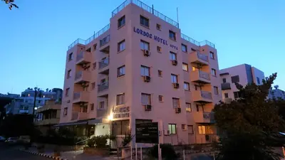a pink building with a sign on it at Lordos Hotel Apts Limassol in Limassol
