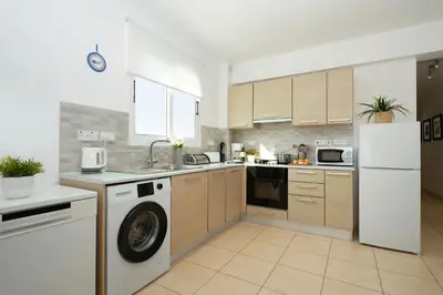 a kitchen with a washer and a sink and a refrigerator at Neraida - 2Bed Apart walk to Kalamies Beach in Protaras