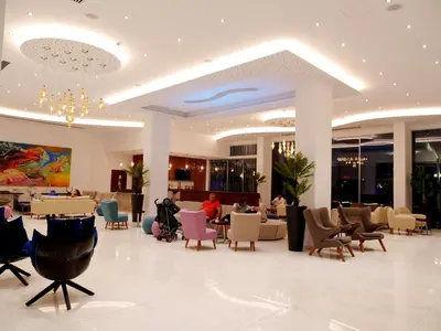 a lobby with a restaurant with tables and chairs at Amethyst Napa Hotel & Spa in Ayia Napa