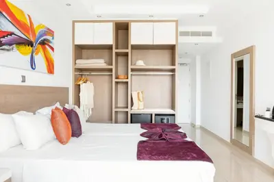 a bedroom with a large white bed with pillows at Amethyst Napa Hotel & Spa in Ayia Napa