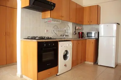 a kitchen with a washing machine and a refrigerator at Makenzy Apartment in Larnaka