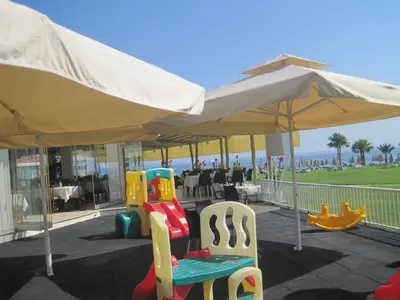a group of chairs under an umbrella next to the beach at Polyxenia Isaak Villa Heaven Pernera in Protaras