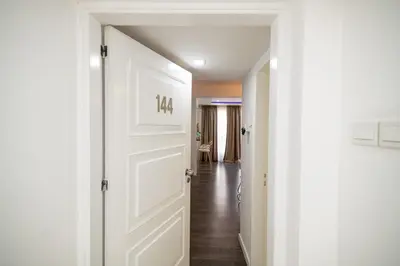 a hallway with a white door and a hallway leading into a room at Lazuli Beachfront Sea View Ap144 in Larnaka