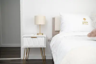 a bed with a side table with a lamp on it at Lazuli Beachfront Sea View Ap144 in Larnaka