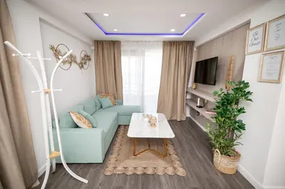 a living room with a blue couch and a table at Lazuli Beachfront Sea View Ap144 in Larnaka