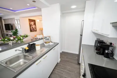 a kitchen with white cabinets and a sink at Lazuli Beachfront Sea View Ap144 in Larnaka