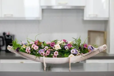 a basket of flowers on a counter in a kitchen at Lazuli Beachfront Sea View Ap144 in Larnaka