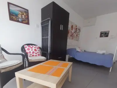 a small living room with a table and a bed at Studio Apartment Near the Beach in Larnaka