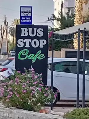 a bus stop cave sign next to a white car at Studio Apartment Near the Beach in Larnaka