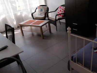 a room with two chairs and a table and a crib at Studio Apartment Near the Beach in Larnaka