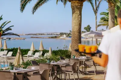 a person holding a bowl of oranges in front of a restaurant at Nissi Beach Resort in Ayia Napa