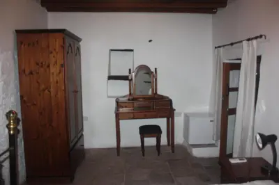 a dressing table with a mirror and a chair in a room at Maritsa Lodge in Kakopetria