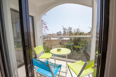 a balcony with chairs and a table and a window at Ha.De.Co. Holiday Apts in Ayia Napa