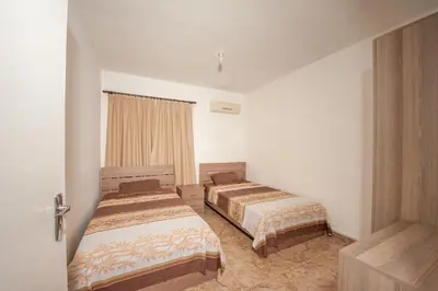 a bedroom with two beds and a window at Ha.De.Co. Holiday Apts in Ayia Napa
