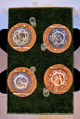 a table with blue and white plates on top of grass at Fat Cow Apartment 101 in Larnaka