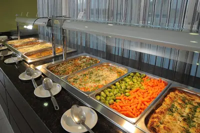 a buffet line with trays of different types of food at Euronapa Hotel Apartments in Ayia Napa
