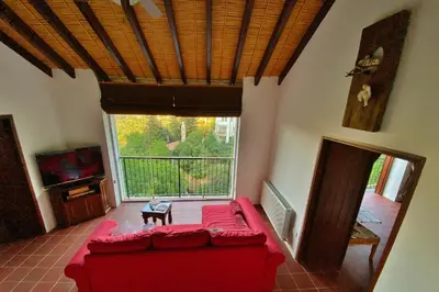 a living room with a red couch and a large window at Arhontiko Askas Mansion in Askas