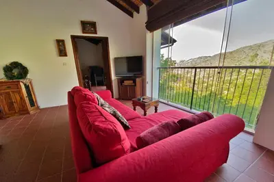 a red couch in a living room with a large window at Arhontiko Askas Mansion in Askas
