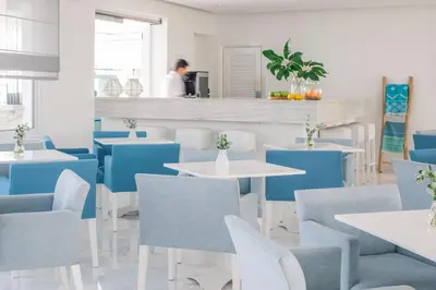 a restaurant with blue and white tables and chairs at Nissi Park Hotel in Ayia Napa