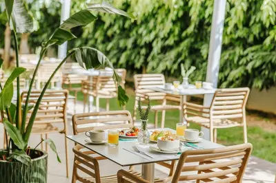 a table with plates of food and cups and chairs at Nissi Park Hotel in Ayia Napa