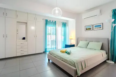 a bedroom with a bed with a teddy bear on it at Mackenzie Blu Beach Studio in Larnaka