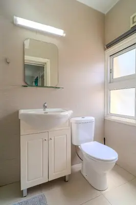 a bathroom with a toilet and a sink and a mirror at Mackenzie Blu Beach Studio in Larnaka