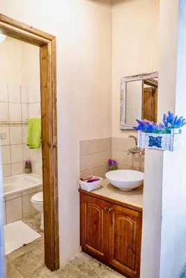 a bathroom with a sink and a toilet and a mirror at Listed Villa in Laneia in Lania