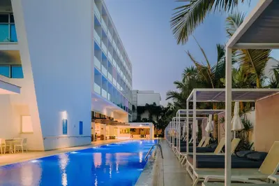 a hotel swimming pool with chairs and a building at Seasons Hotel (Adults Only) in Ayia Napa