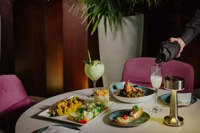 a table with two plates of food and a drink at Seasons Hotel (Adults Only) in Ayia Napa