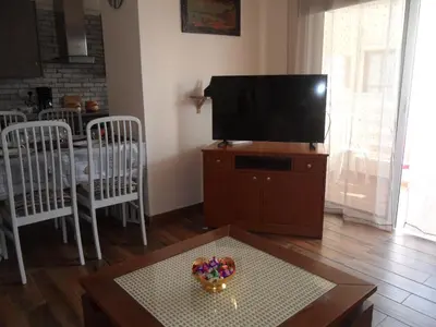 a living room with a television and a table with a bowl of candy at SUNSHINE APTS, TWO BEDROOM , FREE INTERNET, No 3 in Ayia Napa