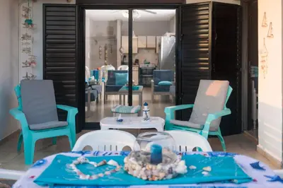 a living room with chairs and a table with at Annita Court Block B, Apt6 in Ayia Napa