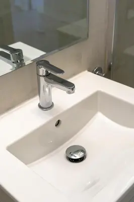 a bathroom sink with a faucet and a mirror at Lazaros Suite Downtown in Larnaka
