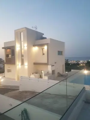a house with a swimming pool next to a building at Villa Chrystalleni in Protaras