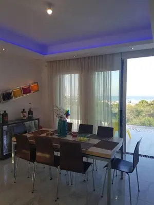 a dining room with a table and chairs and a large window at Villa Chrystalleni in Protaras