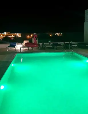 a swimming pool at night with a green illumination at Villa Chrystalleni in Protaras