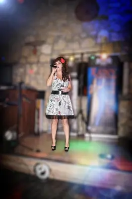 a woman in a dress talking on a cell phone at Antonis G. Hotel Apartments in Voroklini