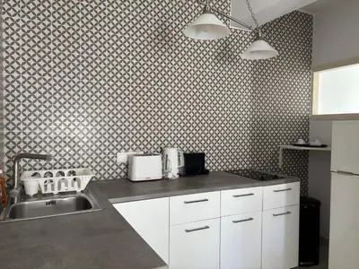 a kitchen with white cabinets and a sink at Vega Apartments in Limassol