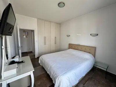 a bedroom with a bed and a desk and a tv at Vega Apartments in Limassol
