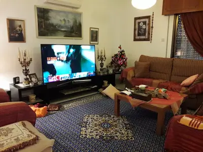 a living room with a flat screen tv and a couch at Shared Top 1st floor villa in Limassol