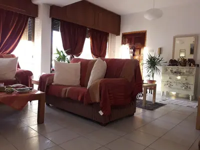 a living room with a red couch and windows at Shared Top 1st floor villa in Limassol